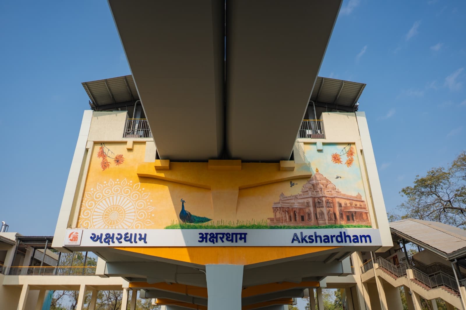 Mural of a peacock and the Akshardham temple beneath the station signage at Akshardham metro station