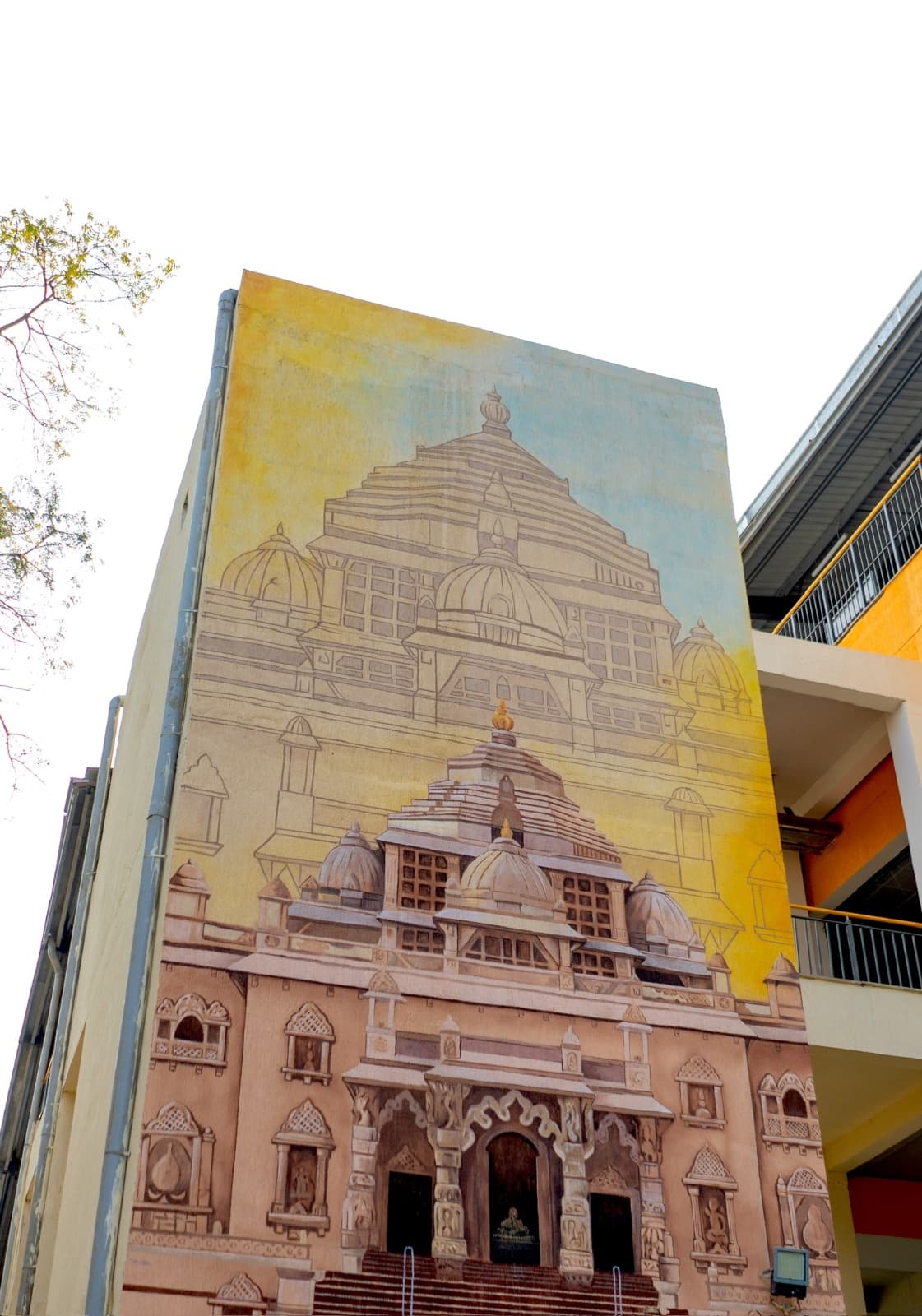 Large-scale mural of the Akshardham temple facade painted across a multi-storey station wall