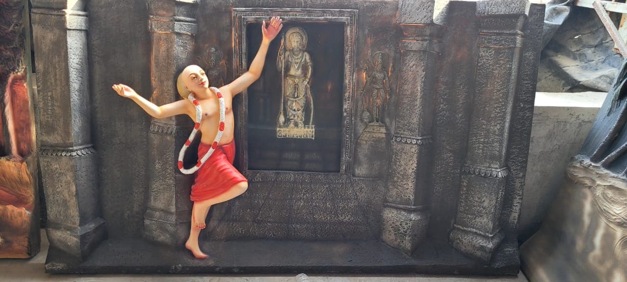 Second view of the FRP relief panel of a devotee in an ecstatic dance pose beside a temple sanctum